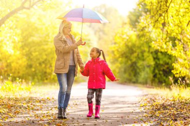 Anne ve kızı bahar sokağında şemsiyeli.