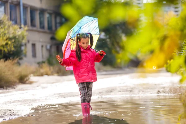 秋の雨の日に屋外でカラフルな傘を持つ愛らしい幼児の女の子 — ストック写真