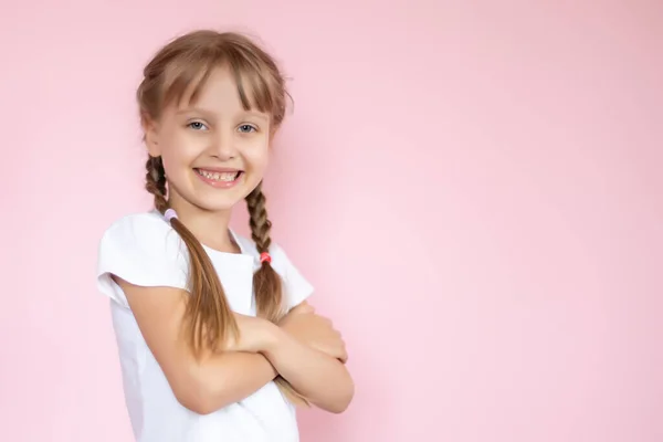 Bella ragazza bionda con i capelli lunghi in bianco T-shirt sorridente su uno sfondo rosa — Foto Stock