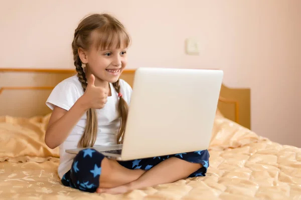 Onderwijs, vrije tijd, technologie en internet concept - kleine student meisje met laptop pc thuis — Stockfoto