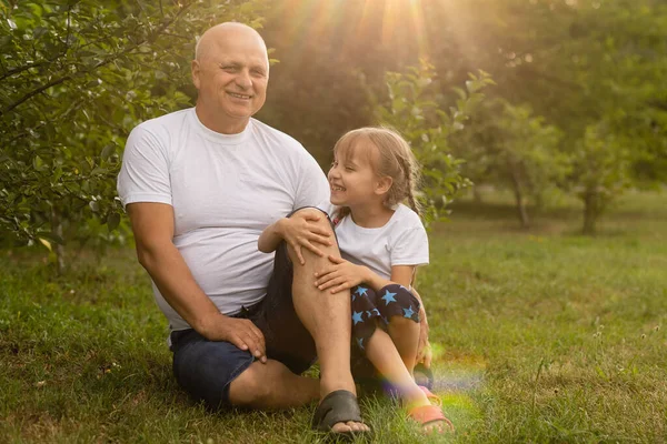 Porträt Großvater mit Enkelin beim gemeinsamen Entspannen im Garten — Stockfoto