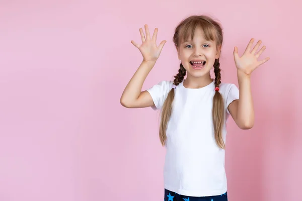 Mooi Klein Meisje Een Wit Shirt Glimlachen Een Roze Achtergrond — Stockfoto