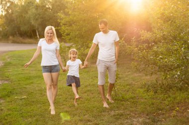 Mutlu bir genç aile yaz günü dışarıda vakit geçirir.