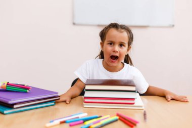 Masadaki küçük kız çığlık çığlığa eğleniyor, ağzı açık