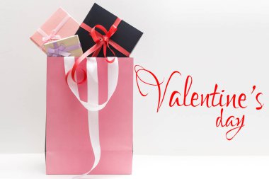 Beyaz arka planda kırmızı fiyonklu küçük bir hediye..