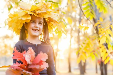 Mutlu küçük çocuk, gülen ve oynayan kız sonbaharda doğa yürüyüşünde.