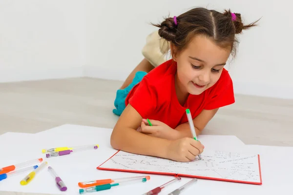 家庭での教育 自宅で床の上に本の山で勉強かわいい女の子 白地に隔離された — ストック写真