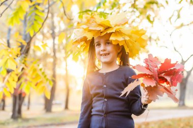 Mutlu küçük çocuk, gülen ve oynayan kız sonbaharda doğa yürüyüşünde.