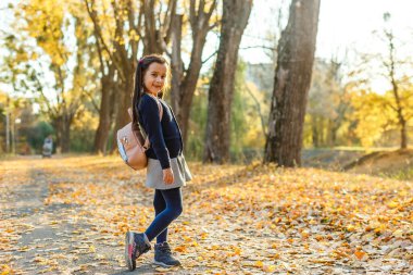 Sırt çantalı tatlı kız okula gidiyor.