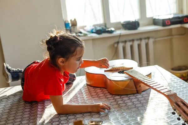 壊れたギターを持っている少女 ギターの修理 — ストック写真