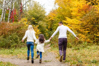Çocuklu aile sonbahar parkına gider.
