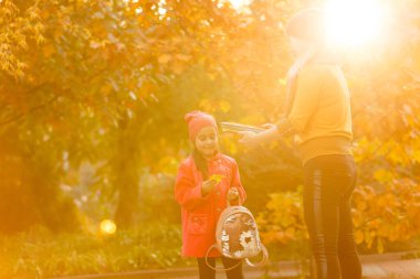Ebeveyn çocuğu okula götürür. Sırt çantalı ilkokul öğrencisi. Anne ve kızı el ele gidiyor. Okula dönelim. Sonbaharın ilk günü. İlkokul öğrencisi. Anaokulu, anaokulu..
