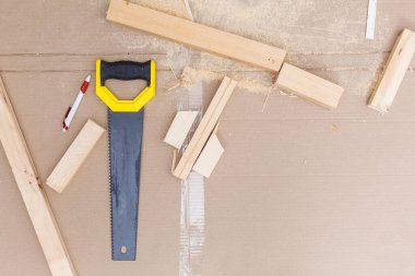 Yuvarlak masanın üzerinde tahta raflar ve dairenin balkonunda mobilya yapan yaşlı bir adam. Ev gelişimi