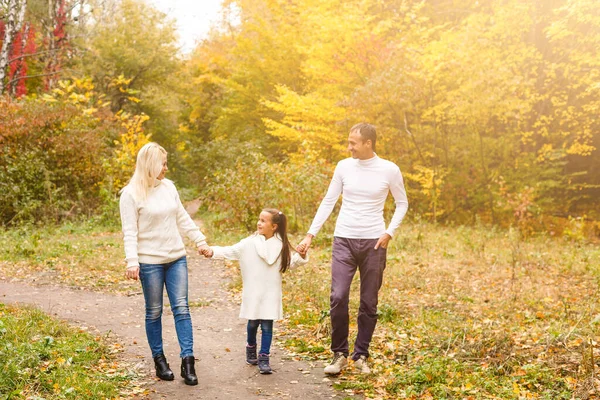 秋の公園で素敵な家族の写真 素敵な愛らしい娘が屋外で遊んでいる若い両親は 秋に裏庭で楽しみ 幸せな家族は秋の自然を楽しむ — ストック写真