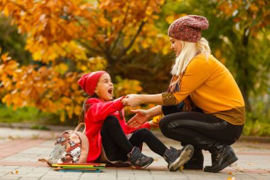 Ebeveyn çocuğu okula götürür. Sırt çantalı ilkokul öğrencisi. Anne ve kızı el ele gidiyor. Okula dönelim. Sonbaharın ilk günü. İlkokul öğrencisi. Anaokulu, anaokulu..