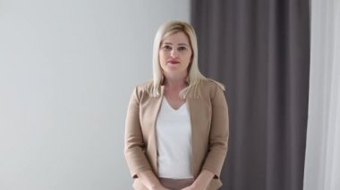 Kendine güvenen kadın ofis çalışanı kulaklık takıyor ve dizüstü bilgisayara bakıyor. Genç iş kadını müşteri hizmetleri müdürü uzaktan iletişim kuran webcam ile konuşuyor..