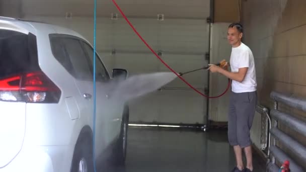 Car wash with high-pressure device. Stream of water in sun rays — Stock videók