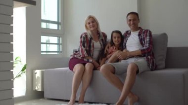 Aile, eğlence ve insan konsepti - mutlu gülümseyen baba, anne ve küçük oğul patlamış mısır yiyor ve akşam evde televizyon izliyor.