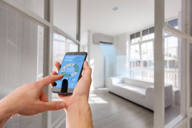Akıllı ev, ev otomasyonu, uygulama simgeli aygıt. Adam akıllı telefonunu akıllı güvenlik uygulaması ile evinin kapısını açmak için kullanıyor..