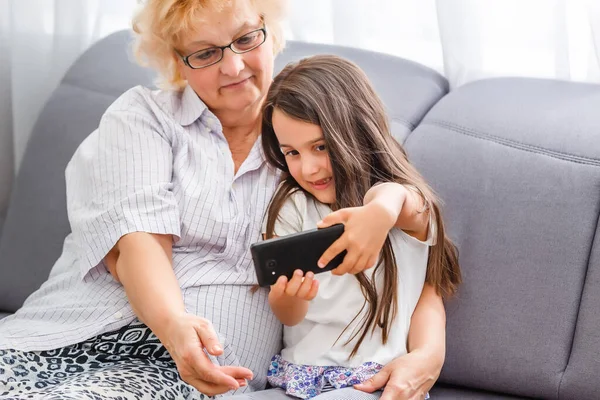 Felice Nonna Nipote Carina Utilizzando Cellulare Insieme Sorridente Nonna Maggiore — Foto Stock