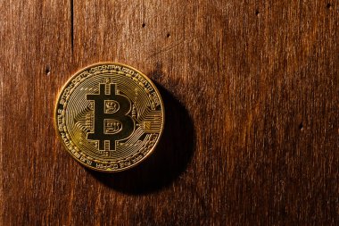 Tahta masa ve bokeh arkaplan üzerindeki altın bitcoin, bitcoin kristal para sembolü engelleme teknolojisinden..