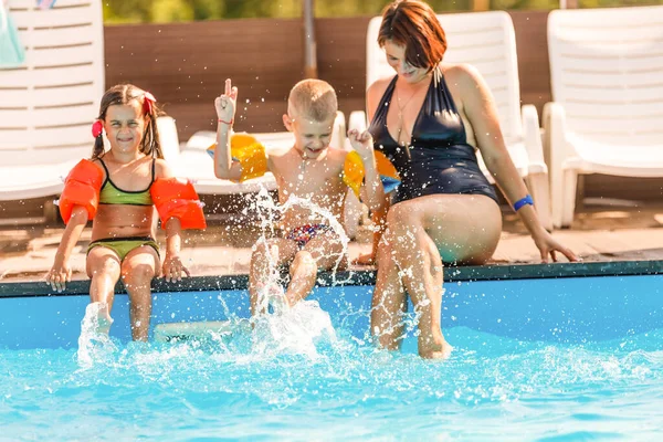 Zwei Frauen und ihre Kinder im Pool — Stockfoto