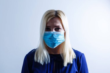 Virüs ya da kirlilikle başa çıkmak için maske takan mutsuz bir kadın..