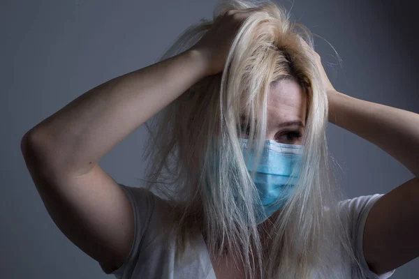 An unhappy woman wearing a face mask to deal with virus or pollution.