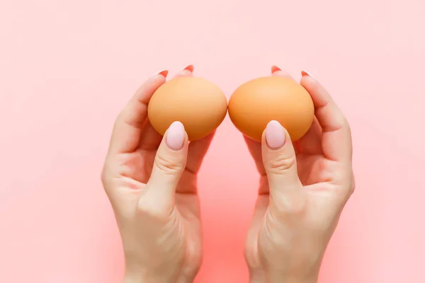 Два Яйця Руці Тримається Рожевому Тлі — стокове фото