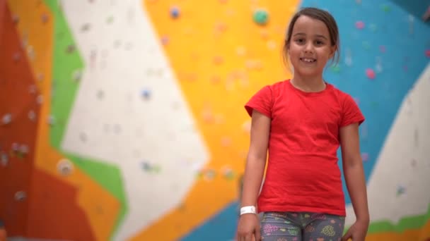 一个小女孩在一个摇摇晃晃的体育馆里爬上了墙 — 图库视频影像