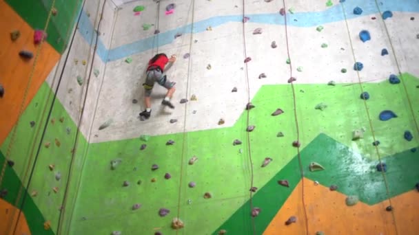 岩の多いジムで壁を登る少女 — ストック動画