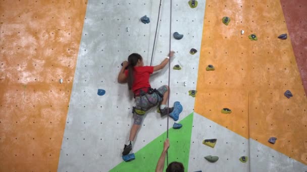 岩の多いジムで壁を登る少女 — ストック動画