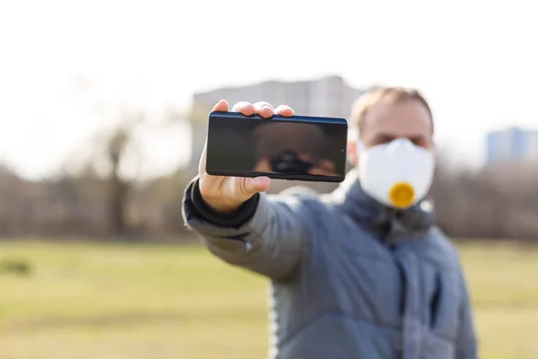 Asian man wearing the face mask due to air pollution - Young adult on park with Pollution mask - person protecting from air contamination or coronavirus or covid-19 by wearing mask.