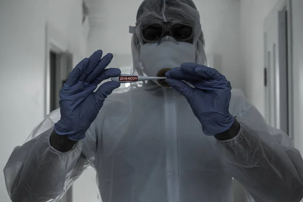 Scientist in protective gear with arms crossed in laboratory