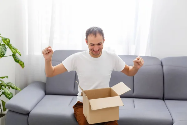 Happy man with an open box in an apartment