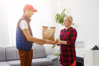 Şoför elinde kese kâğıdıyla marketten sipariş veriyor.