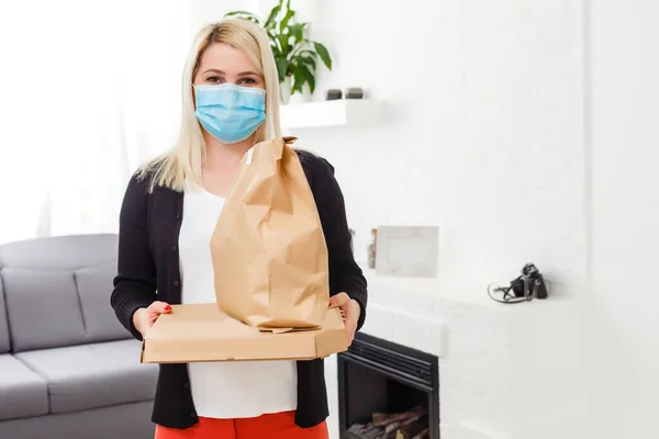 Ung Kvinna Bär Medicinsk Mask Emot Paket Från Leverans Man — Stockfoto
