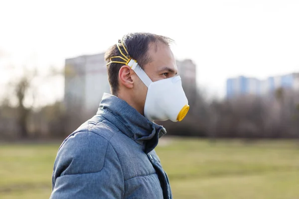 Asian man wearing the face mask due to air pollution - Young adult on park with Pollution mask - person protecting from air contamination or coronavirus or covid-19 by wearing mask.