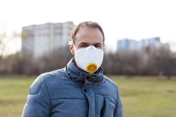 Asian man wearing the face mask due to air pollution - Young adult on park with Pollution mask - person protecting from air contamination or coronavirus or covid-19 by wearing mask.