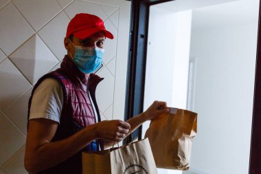Yiyecek teslimatçısı, tıbbi maske takıyor. Corona Virüsü Konsepti
