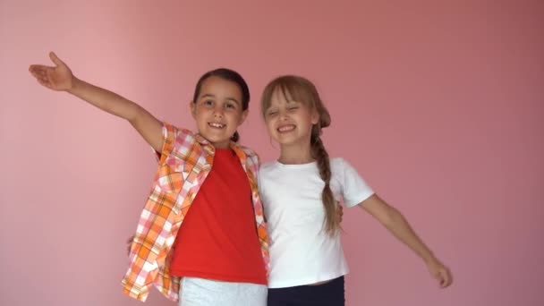 Piccole Ragazze Sorridenti Sorelle Migliori Amici Abbracciano Uno Sfondo Rosa — Video Stock