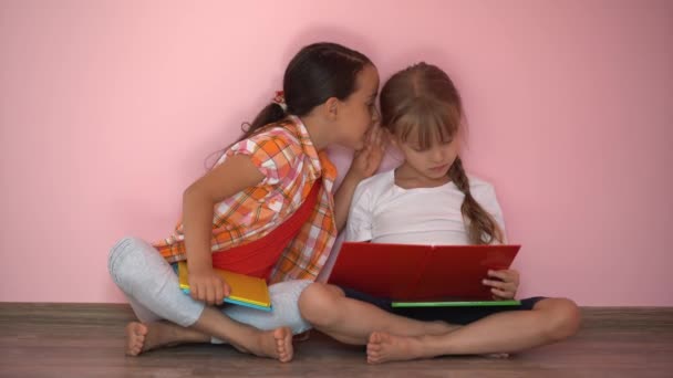 Två Små Flickor Läser Böcker Rosa Bakgrund — Stockvideo
