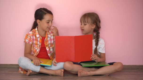 Twee Kleine Meisjes Lezen Boeken Een Roze Achtergrond — Stockvideo