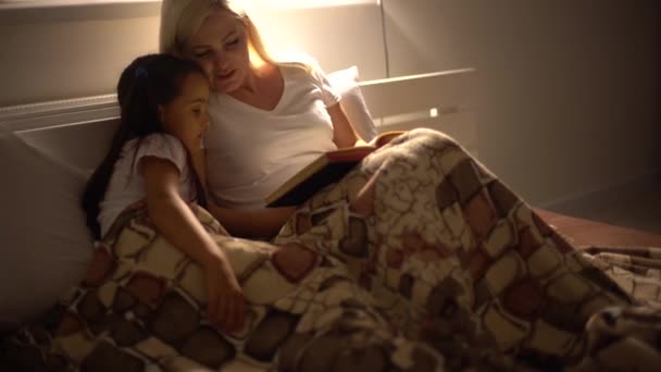 Una Joven Madre Lee Libro Una Biblia Hija Sentada Sofá — Vídeos de Stock