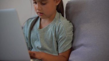 Tatlı çocuk eğitim için dizüstü bilgisayar kullanıyor, online çalışma. Kızın evde ödevi var..