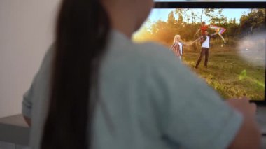 Küçük şirin kız dizüstü bilgisayardaki aile fotoğraflarına bakıyor. Modern teknolojilerin yardımıyla çocukların eğlencesi, eğlencesi ve eğitimi.