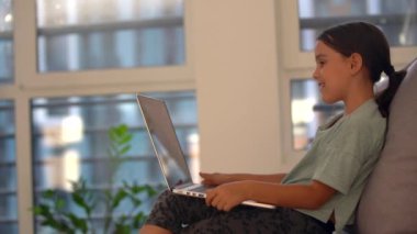 Tatlı çocuk eğitim için dizüstü bilgisayar kullanıyor, online çalışma. Kızın evde ödevi var..