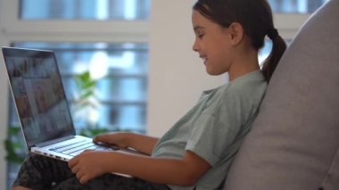 Tatlı çocuk eğitim için dizüstü bilgisayar kullanıyor, online çalışma. Kızın evde ödevi var..