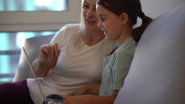 Online μάθηση, εξ αποστάσεως εκπαίδευση, η μητέρα βοηθά το κοριτσάκι με την εργασία στον υπολογιστή. — Αρχείο Βίντεο