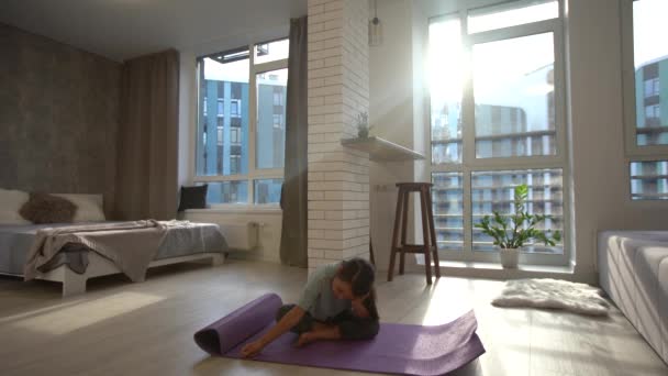 Smiling little girl doing work out in light room — Stock Video